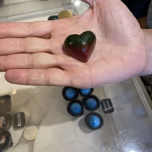 a hand holding a chocolate heart