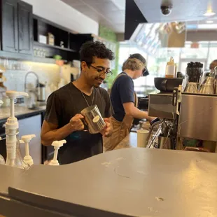 a man standing at a counter in a coffee shop