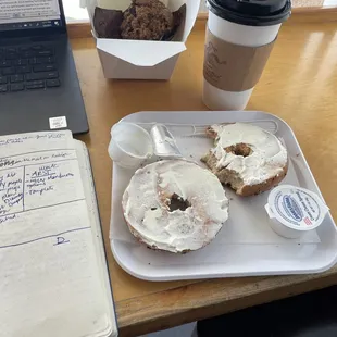 a bagel with cream cheese frosting and a cup of coffee