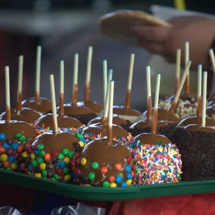 a tray of candy apples with sprinkles