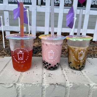 three different drinks in plastic cups