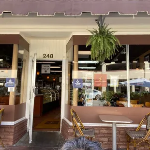 a man sitting at a table in front of a store