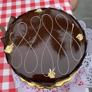 a chocolate cake on a red and white checkered tablecloth