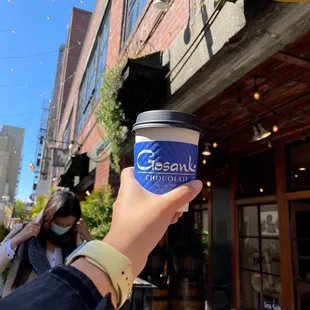 a hand holding a cup of coffee