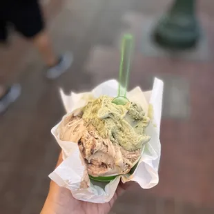 a hand holding a cup of ice cream