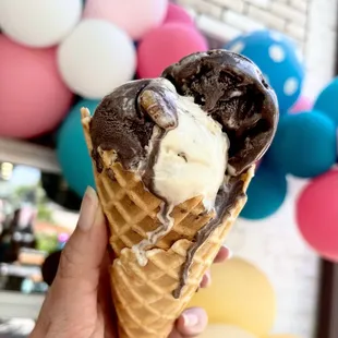 a hand holding an ice cream cone