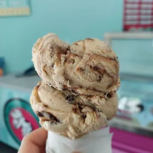 a hand holding a cone of ice cream