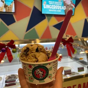 a hand holding a cup of ice cream