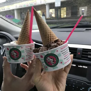 two people holding up ice cream cones