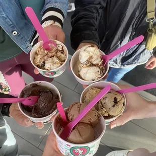 a group of people holding cups of ice cream