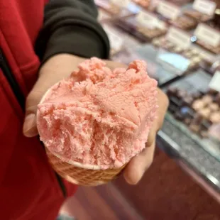 a person holding a cone of ice cream