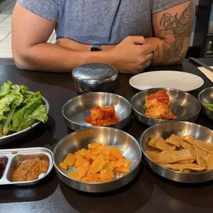 a man sitting at a table with bowls of food