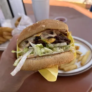 a hand holding a hamburger