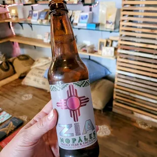 a hand holding a bottle of beer