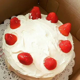 Vanilla cake with fresh strawberry filling, topped with fresh strawberries