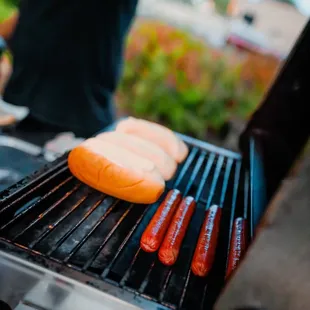 hotdogs and buns on a grill