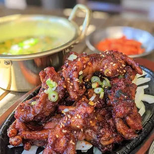 a plate of chicken wings and a bowl of soup