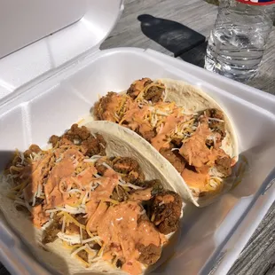 two tacos in a styrofoam container