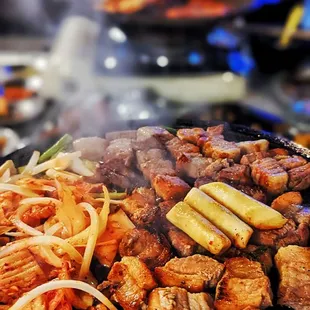a variety of food cooking on a grill