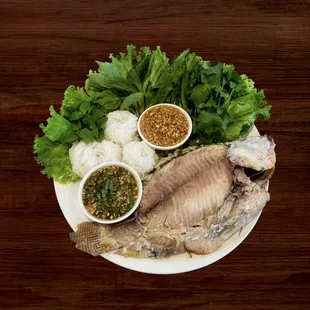 Pla Pao (Grilled whole herbs Tilapia with vermicelli, fresh vegetables, spicy sauce, sweet peanut sauce)