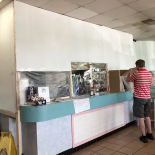 a man standing at a counter in a restaurant