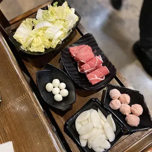 Hot pot fixings: Napa cabbage, lamb, fish balls, quail eggs, rice cake.