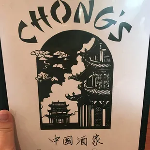 a hand holding a menu