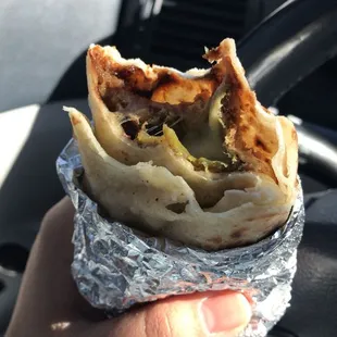 a hand holding a burrito