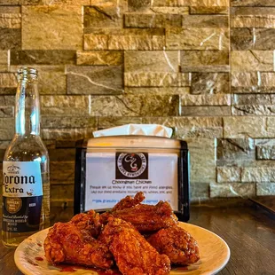 a plate of chicken wings and a bottle of beer