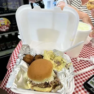 a woman sitting at a table with a tray of food