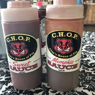 two bottles of barbecue sauce on a table