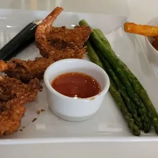 Steak and coconut shrimp asparagus, and fries