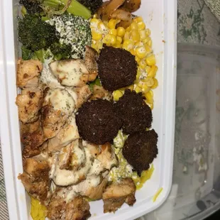 Rice Bowl chicken and falafel. Yellow rice, broccoli, corn, and white sauce.