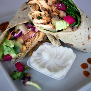 a chicken wrap with a side of ranch dressing
