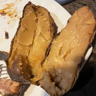 Old, hard baked potato served with entree.