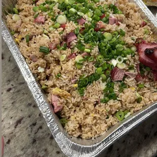 a pan of rice with meat and vegetables