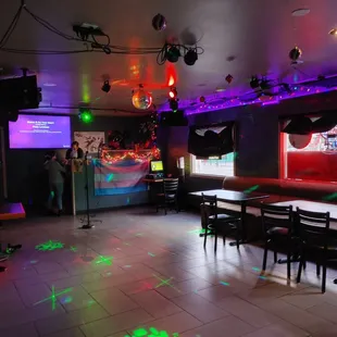 a brightly lit bar with tables and chairs