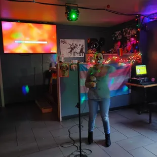 a woman singing in front of a microphone