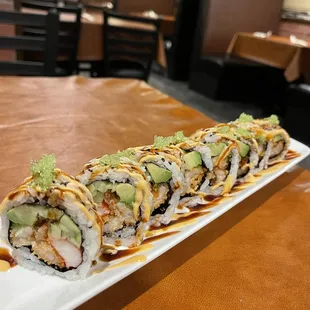 a sushi roll with avocado and sauce