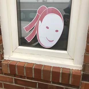 a sticker of a woman&apos;s face in a window