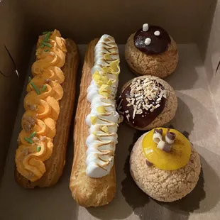 Box of goodies: Peach Cobbler &amp; Lemon Meringue eclairs; Hot Chocolate, Coconut Mounds &amp; Bananas Foster Choux Puffs