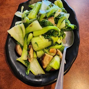 Stir fry Chinese mushrooms over greens