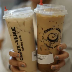 a woman holding two cups of coffee