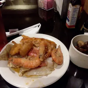 Seafood plate with a side of dumplings and a cup of mushroom as well as it&apos;s unsweetened tea.