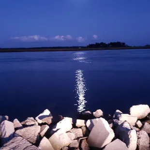 the moon setting over the water