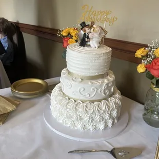 Vanilla buttercream frosting with a Vanilla layer (6&quot;), lemon (8&quot;) and almond (10&quot;). Figurine and &quot;happy anniversary&quot; topper added by me.