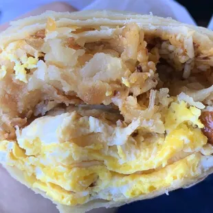 Inside of sausage breakfast burrito. You can see salsa in top right mixed in with cheese.