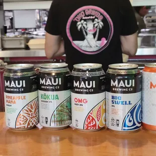  man behind a counter with cans of beer