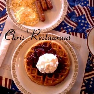  plate of waffles, sausages, and eggs