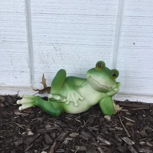  statue of a frog laying on the ground